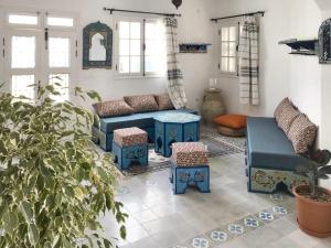 a living room with blue furniture and a potted plant at Spacious villa with private pool in Djerba in Houmt Souk