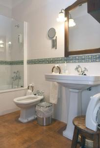 La salle de bains est pourvue d'un lavabo, de toilettes et d'un miroir. dans l'établissement Casa de los Acacio, à San Clemente