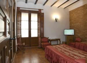 a bedroom with two beds and a tv in a room at Casa de los Acacio in San Clemente