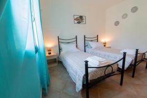 two twin beds in a room with a window at Casa Martina in Pula