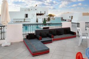 a patio with a couch and chairs on a balcony at Spacious villa with private pool in Djerba in Houmt Souk