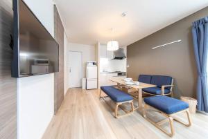 a kitchen and dining room with a table and chairs at Logement Aile 203 in Takasaki