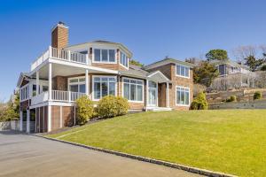 una casa grande con césped delante en Hamptons Home Near Beaches with Pool and Water Views! en Southampton