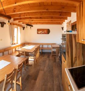 een keuken en eetkamer met houten tafels en stoelen bij Vinotoč pri Jožici in Škocjan