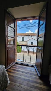 an open door to a balcony with a view of a building at La Culta hostal & centro cultural in Sucre