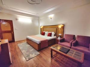 une chambre d'hôtel avec un lit et un canapé dans l'établissement Hotel Surya International - Manali, à Manali