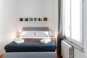 1 dormitorio con 1 cama con 2 toallas en Como Luxury Suites - IL DUOMO, en Como