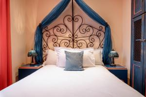a bedroom with a large bed with a blue headboard at Villa Royale Montsouris in Paris