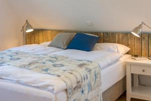 a bed with a blue and white blanket on it at Nordsee Liebe Haus A in Spiekeroog