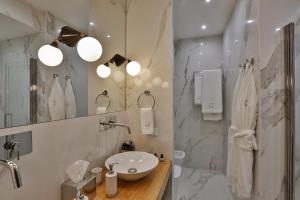 ein weißes Badezimmer mit einem Waschbecken und einem Spiegel in der Unterkunft CASTELLO DANS LES POUILLES DU SUD in Galatina
