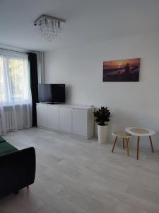a living room with a tv and a table at Kawalerka apartament ul gieldowa in Kołobrzeg