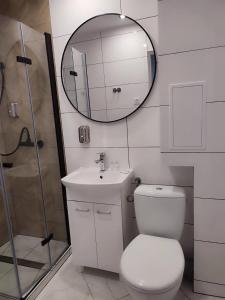 a bathroom with a toilet and a sink and a mirror at Kawalerka apartament ul gieldowa in Kołobrzeg