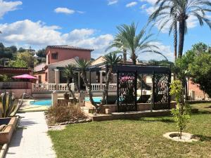 une maison avec une piscine et des palmiers dans l'établissement Villa de 4 chambres avec piscine privee jardin clos et wifi a Villeneuve Loubet, à Villeneuve-Loubet
