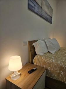 モドゥーニョにあるSantalucia Suiteのベッドルーム1室(ベッド1台、テーブルの上にランプ付)