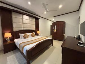a bedroom with a bed and a dresser and a television at Serenity Villa Digana in Kandy