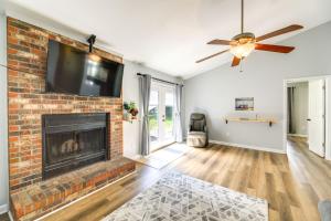 a living room with a brick fireplace with a flat screen tv at Charming Jacksonville Abode with Patio! in Jacksonville