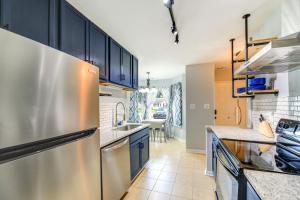 cocina con armarios azules y nevera de acero inoxidable en Charming Jacksonville Abode with Patio!, en Jacksonville