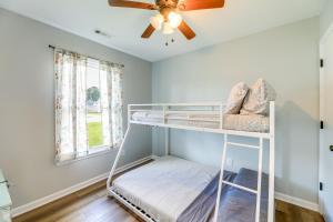 ジャクソンビルにあるCharming Jacksonville Abode with Patio!の二段ベッド、天井ファンが備わる客室です。