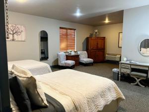 a bedroom with two beds and a desk and a sink at The Bank Hotel in Lake Arthur