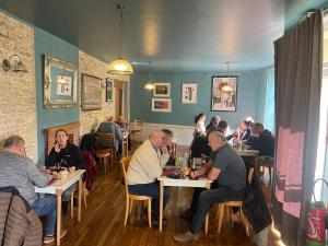 a group of people sitting at tables in a restaurant at Le Diamant Chambrés in Mauprévoir