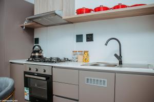 a small kitchen with a stove and a sink at Casa de Amor - Stylish Apartment in Rosebank in Johannesburg