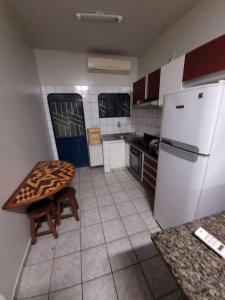 a kitchen with a table and a white refrigerator at Apartamento em Jardim Floresta in Boa Vista