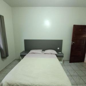 ein Schlafzimmer mit einem großen Bett und einem Holzschrank in der Unterkunft Apartamento em Jardim Floresta in Boa Vista
