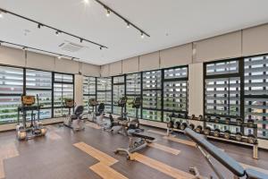 a gym with rows of exercise equipment and windows at Highpark Suites at Petaling Jaya, Kelana Jaya by Plush in Petaling Jaya