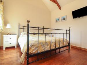 una camera con letto e TV a parete di Long Barn a Penzance