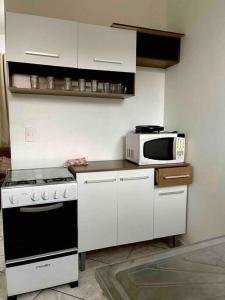 uma cozinha com um fogão e um micro-ondas em Apartamento 5 km do aeroporto em Brasília