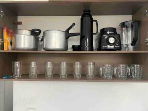 a shelf with cups and a coffee pot and a camera at Apartamento 5 km do aeroporto in Brasília +6 photos