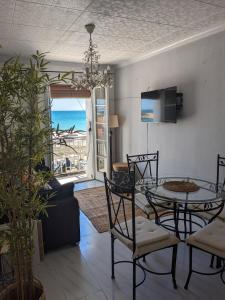 - un salon avec une table et des chaises donnant sur l'océan dans l'établissement ALCANAR DEL MAR, à Les Cases d'Alcanar
