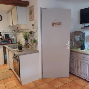 eine weiße Tür in einer Küche mit einer Theke in der Unterkunft Studio Le clos des vins d'Anges in Saint-Pierre-des-Champs