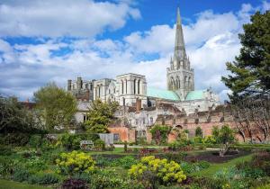 a view of a cathedral with a garden in front at Cawley Priory - Family Friendly, City Centre Apartment, Sleeps 4 in Chichester