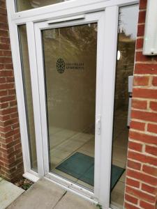 a glass door of a building with a sign on it at Chichester Retreat - Quiet City Centre Apartment in Chichester