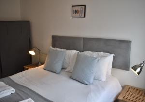 a bedroom with a bed with white sheets and pillows at Cathedral View - Chichester City Centre Top Floor Apartment in Chichester
