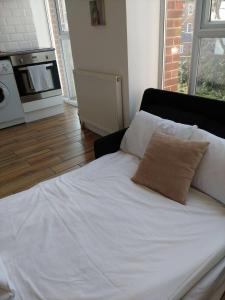 a white bed with a pillow on it in a room at Canal Walk - Chichester City Centre Apartment in Chichester