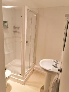 a white bathroom with a shower and a sink at Chichester Quarters - Ground Floor, City Centre, 2 Bedroom Apartment in Chichester