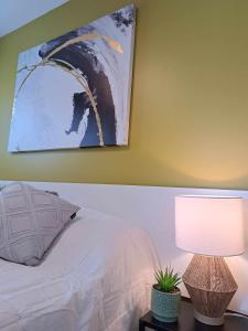1 dormitorio con 1 cama y una pintura en la pared en Habitations Zenith en Sainte-Anne-de-Beaupré