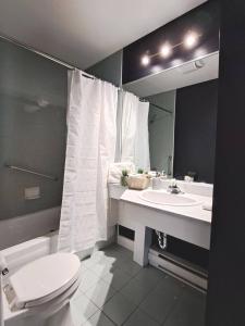 y baño con aseo blanco y lavamanos. en Habitations Zenith en Sainte-Anne-de-Beaupré
