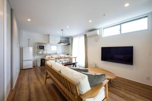 a living room with a couch and a table at Aile House Ⅰ in Takasaki