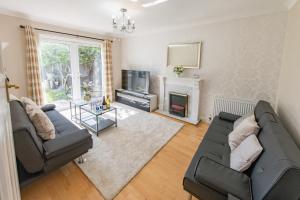 a living room with two couches and a fireplace at Cosy Family Home in Ruislip in Ruislip
