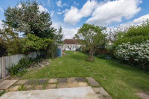 a yard with a fence and trees and a house at Cosy Family Home in Ruislip in Ruislip