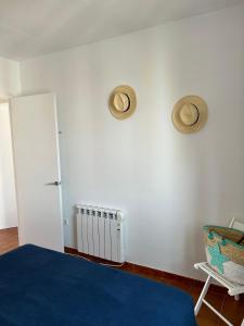 um quarto com uma cama e dois chapéus na parede em Apartamento junto a Es Clot de Sa Cera a 5 min Ciutadella em Cala Santandria