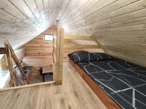 a room with a bed in a tiny house at Domki Bory Tucholskie - Kurs na wypoczynek in Osieczna