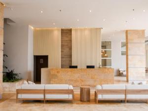 een lobby met witte banken en een bar bij Ciela Hotel in Coveñas