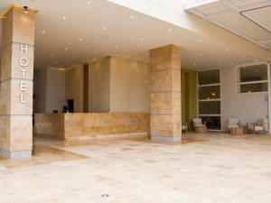 een grote lobby met twee stenen zuilen in een gebouw bij Ciela Hotel in Coveñas