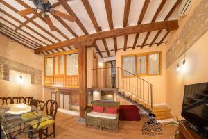 a living room with a staircase and a dining room at Casa de la Mezquita y Casa de Carretas MeninasCollection in Toledo