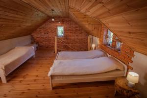 a bedroom with two beds in a attic at Domek Wiejski w Skarlance in Zbiczno
