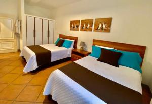 - 2 lits dans une chambre avec 2 lits dans l'établissement Torre Mar Galapagos Boutique Suites, à Puerto Ayora